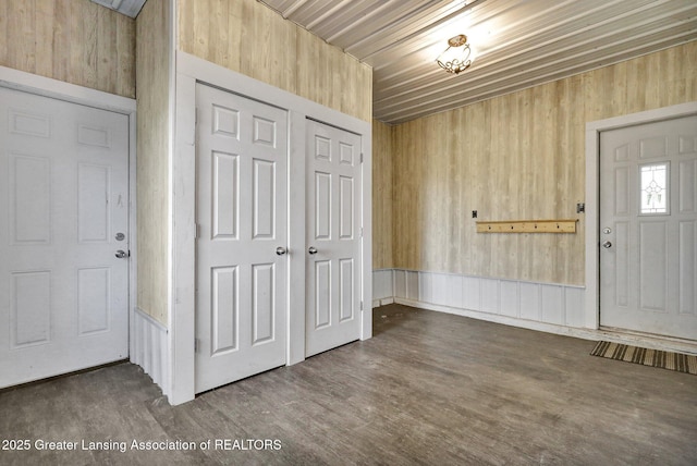 foyer entrance featuring wood finished floors and wood walls