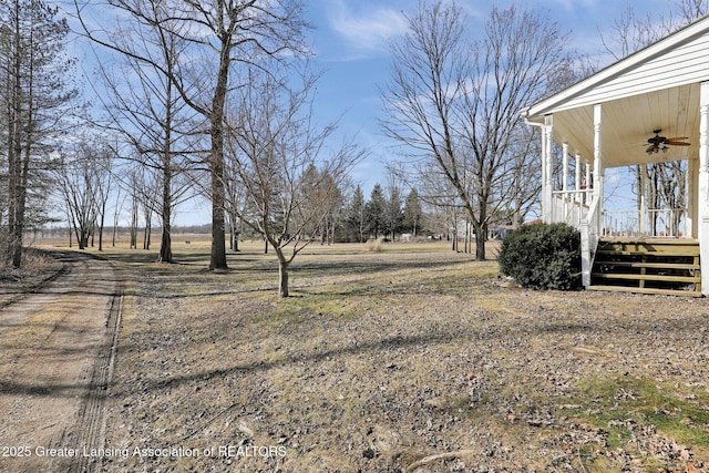 view of yard with a porch and ceiling fan