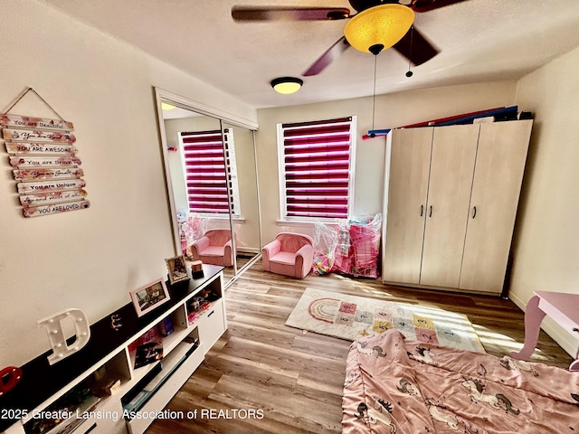 bedroom with wood finished floors, a closet, and ceiling fan