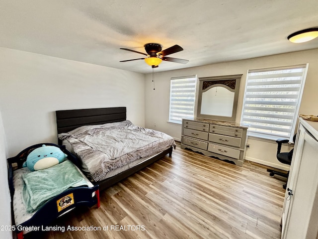 bedroom featuring light wood-type flooring, baseboards, and ceiling fan