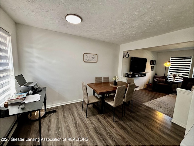 dining space featuring wood finished floors, baseboards, and a textured ceiling