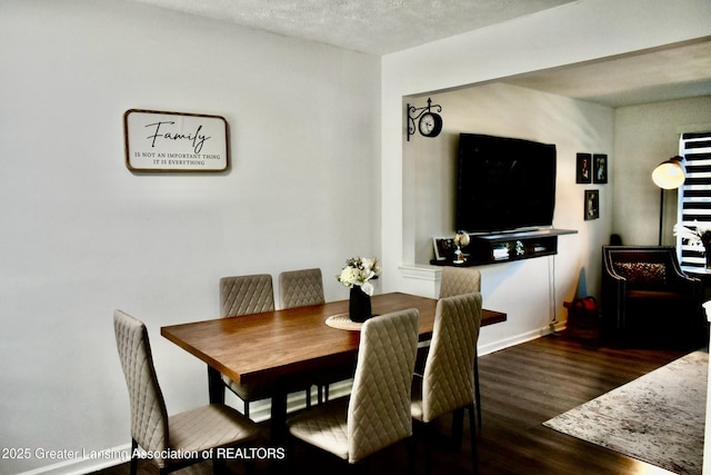 dining area featuring wood finished floors and a textured ceiling