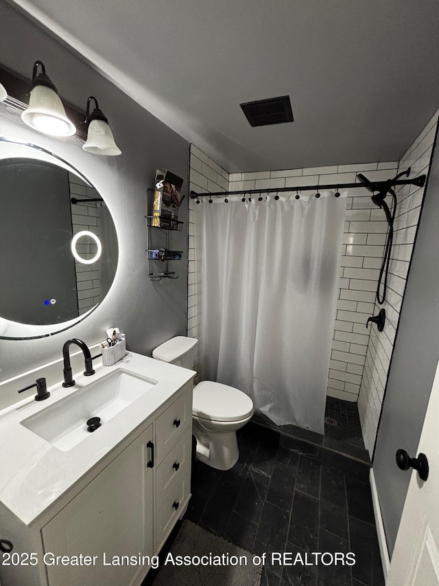 bathroom featuring visible vents, tiled shower, toilet, and vanity