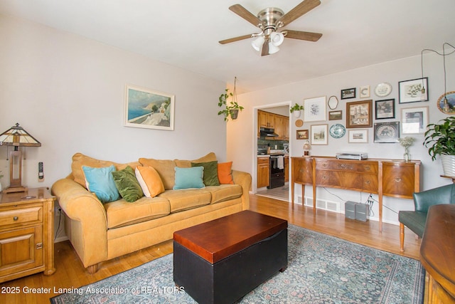 living area featuring ceiling fan and wood finished floors