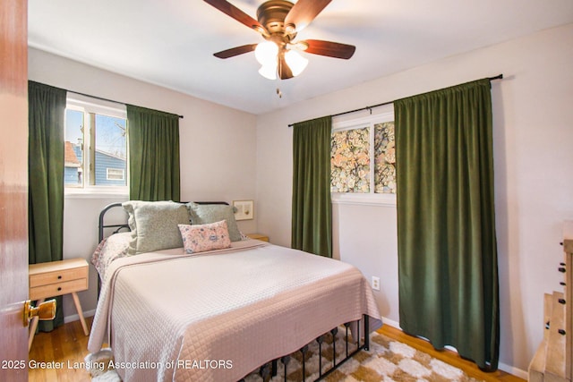 bedroom with baseboards, wood finished floors, and a ceiling fan