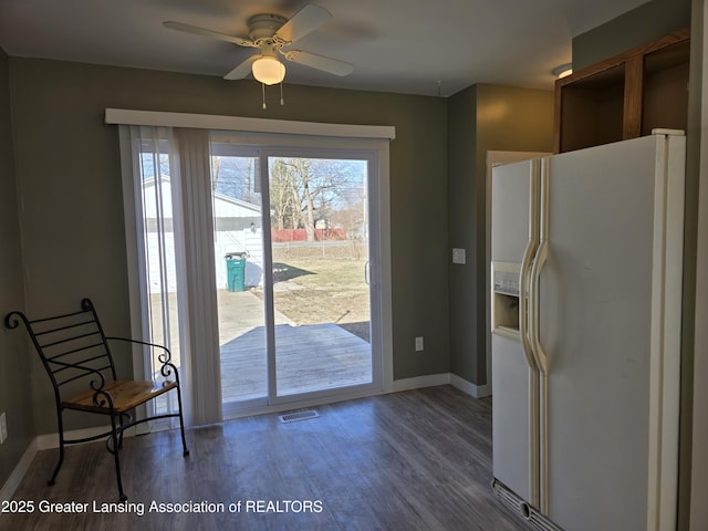 entryway featuring a healthy amount of sunlight, baseboards, a ceiling fan, and wood finished floors