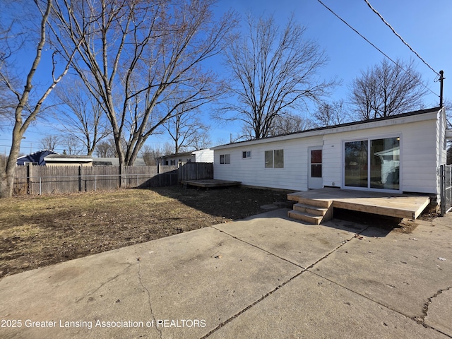 back of house with a patio area, a wooden deck, and fence