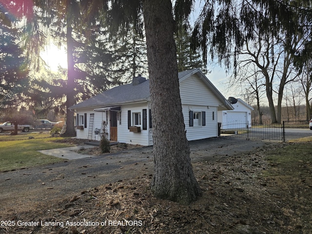 view of front of home with driveway, a chimney, a garage, and fence