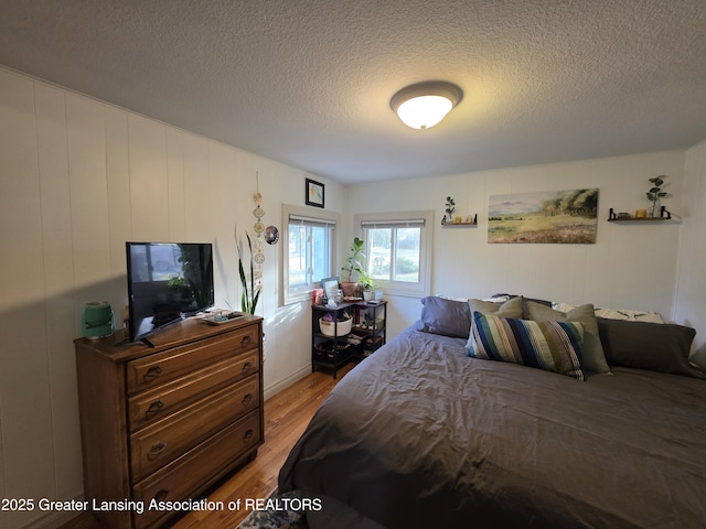 bedroom featuring a textured ceiling and light wood-style flooring