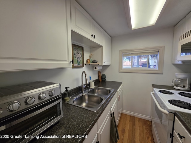 kitchen featuring white appliances, light wood finished floors, a toaster, a sink, and white cabinets