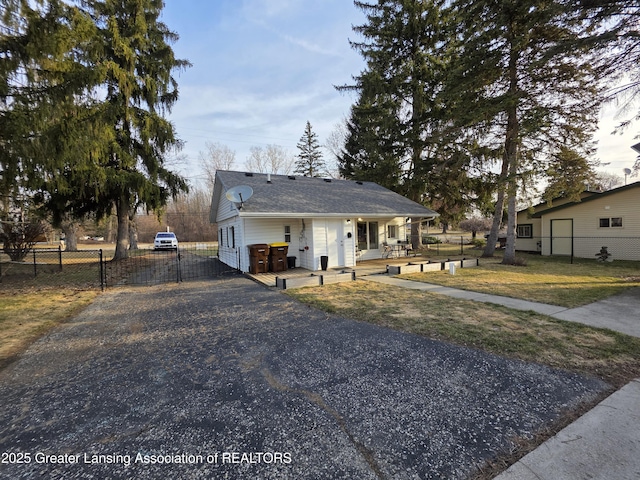 view of front of property with aphalt driveway, a gate, and fence