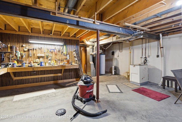 unfinished basement featuring a workshop area and water heater