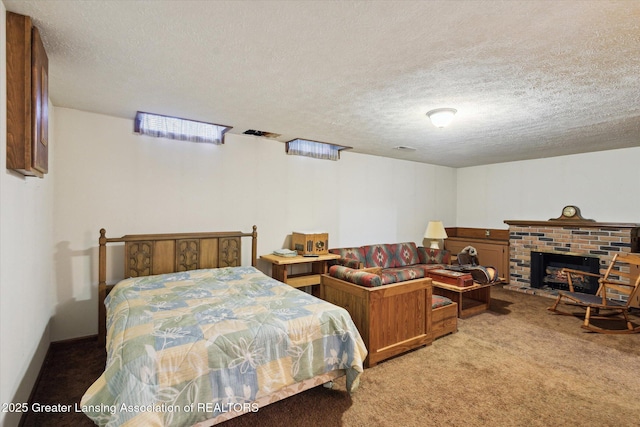 bedroom with a textured ceiling, a brick fireplace, and light carpet