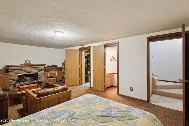 carpeted bedroom with a fireplace, baseboards, and a textured ceiling