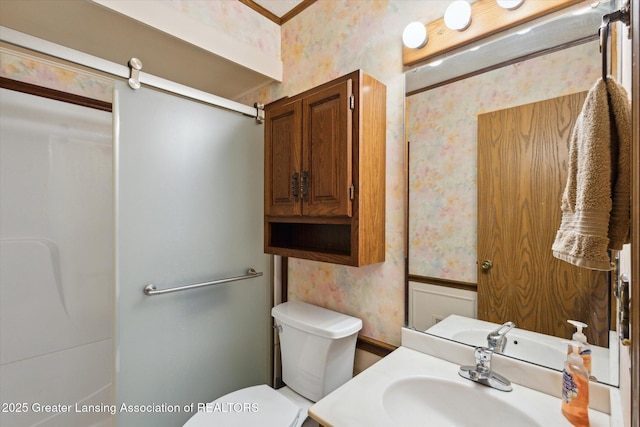 bathroom with toilet, wallpapered walls, vanity, and ornamental molding