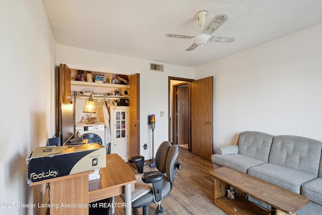 office area featuring visible vents, light wood-type flooring, and ceiling fan