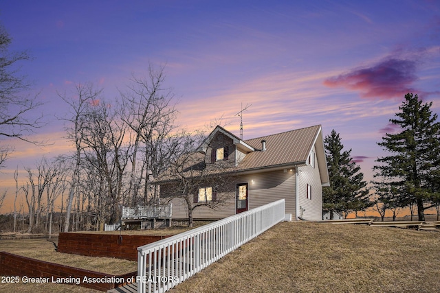 rear view of property featuring metal roof and a yard