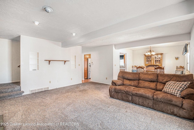 living area featuring visible vents, a textured ceiling, stairs, and carpet floors