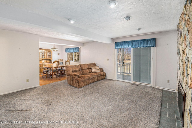 carpeted living room featuring a textured ceiling and baseboards