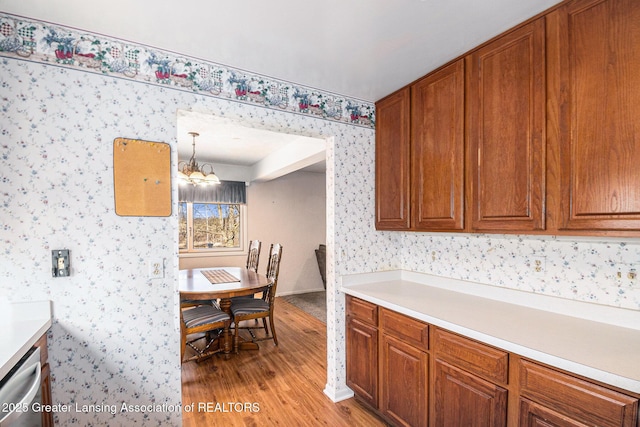 kitchen with light countertops, brown cabinetry, and wallpapered walls