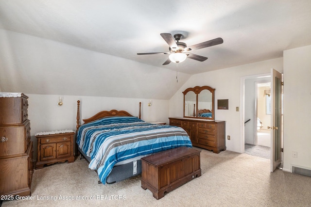 bedroom featuring visible vents, light colored carpet, a ceiling fan, and vaulted ceiling