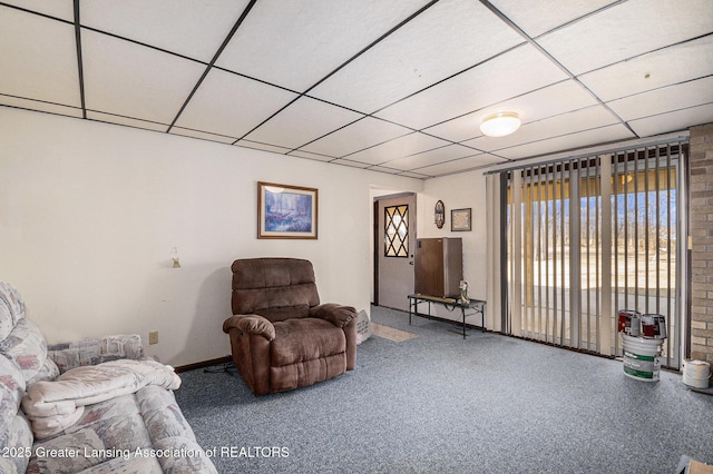 living area with a drop ceiling