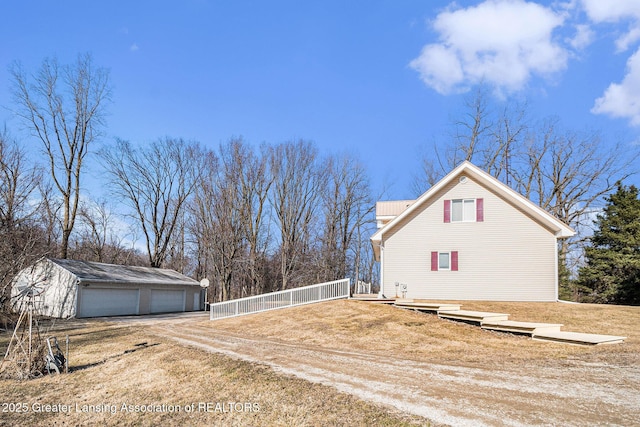 view of property exterior featuring an outdoor structure, a garage, and metal roof