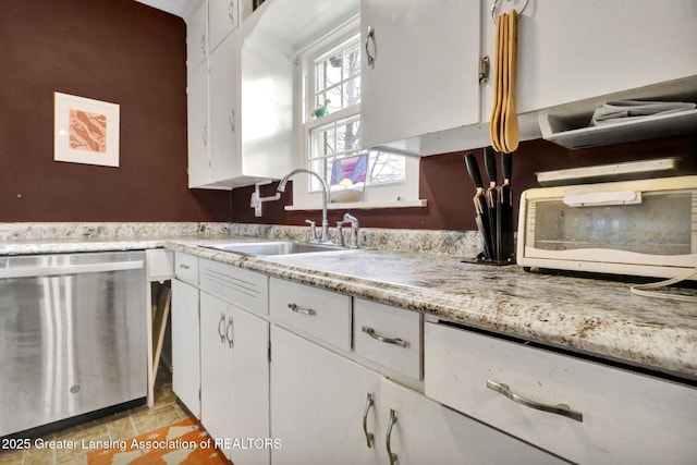 kitchen with dishwasher, white cabinetry, and a sink