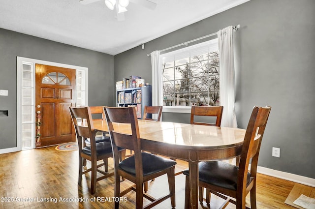 dining space featuring ceiling fan, baseboards, and wood finished floors