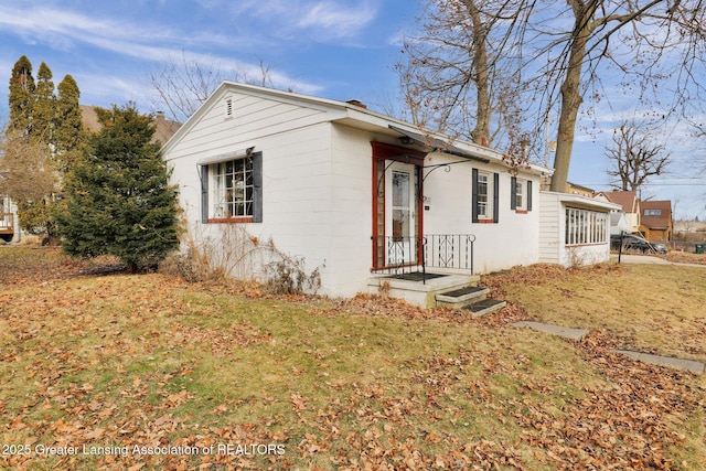 view of front of house featuring concrete block siding and a front yard