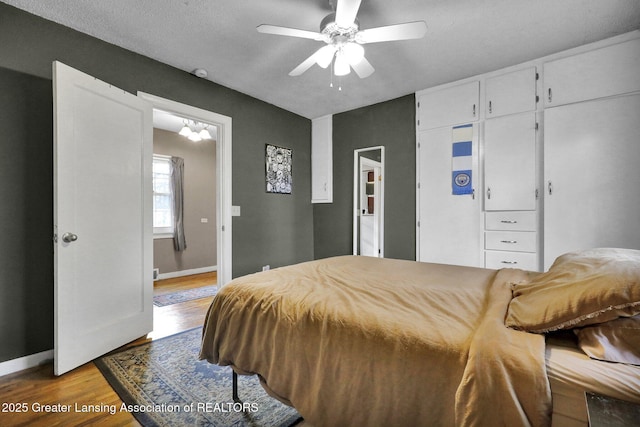 bedroom featuring wood finished floors, baseboards, and ceiling fan