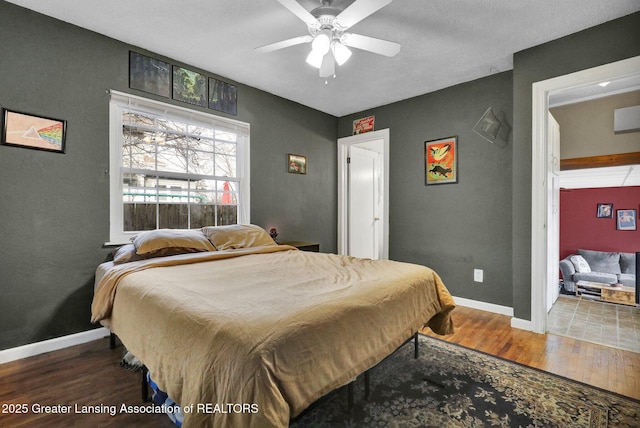 bedroom with a ceiling fan, baseboards, and wood finished floors