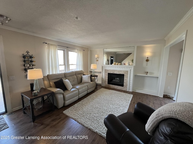 living room featuring a textured ceiling, dark wood-style floors, a fireplace, crown molding, and baseboards