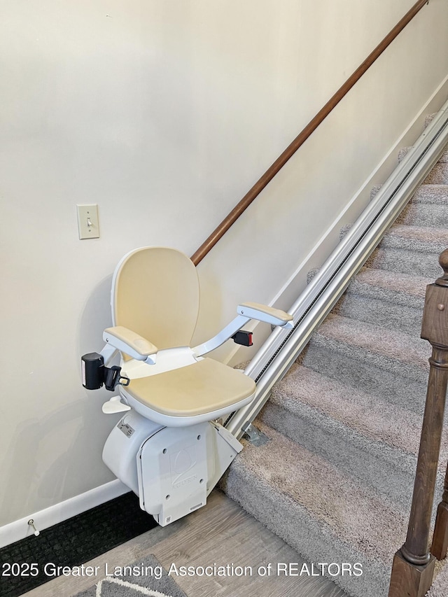 stairway featuring wood finished floors and baseboards