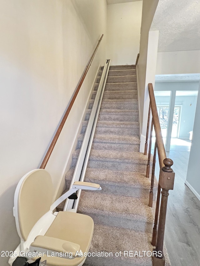 stairway with a textured ceiling