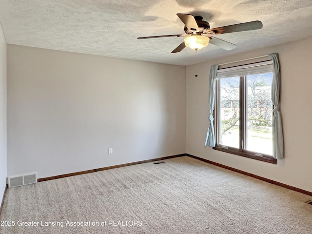 spare room featuring carpet, baseboards, visible vents, and ceiling fan