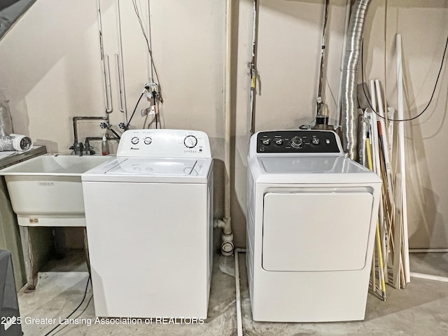 clothes washing area with a sink, laundry area, and washer and clothes dryer