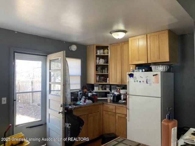 kitchen featuring open shelves, plenty of natural light, dark countertops, and freestanding refrigerator