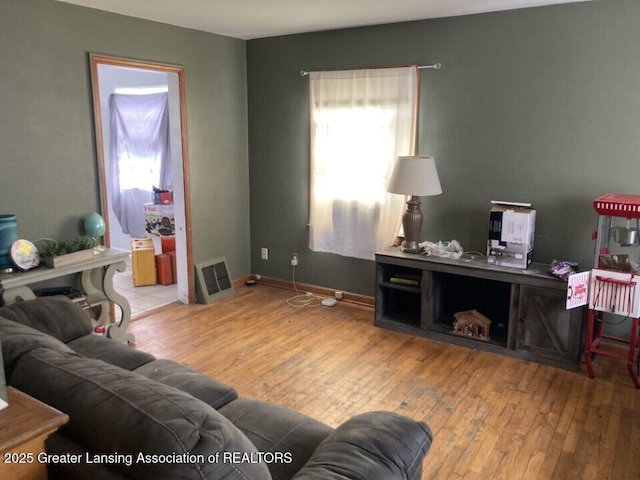 living area with baseboards and wood-type flooring