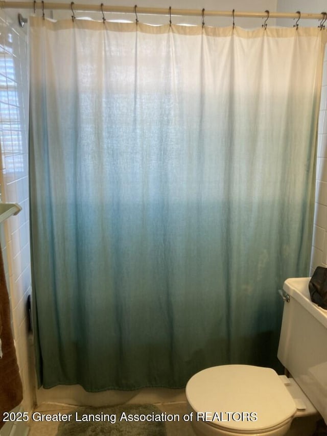 full bathroom with a shower with curtain and toilet