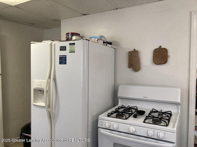 kitchen with white appliances and a paneled ceiling