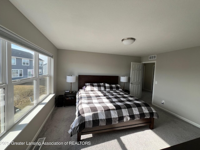 carpeted bedroom featuring visible vents and baseboards