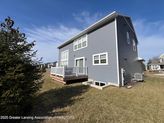 back of property featuring central AC unit, a lawn, and a deck