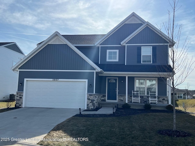 craftsman-style home with a front lawn, driveway, stone siding, a porch, and a garage