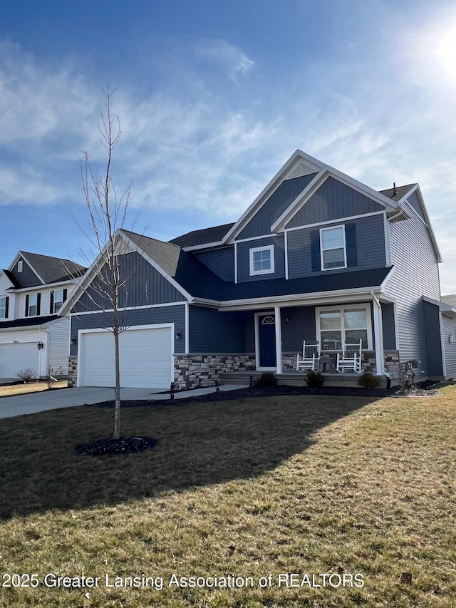 view of front of house featuring driveway, a front lawn, board and batten siding, covered porch, and a garage