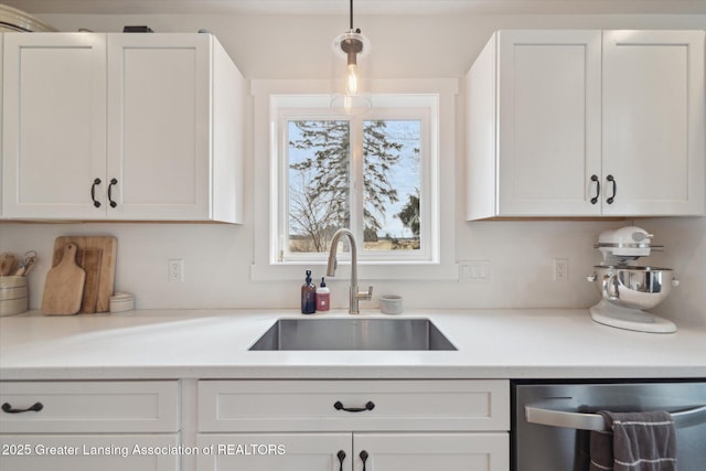 kitchen with dishwasher, light countertops, white cabinetry, and a sink