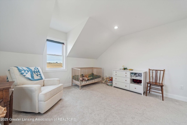 bedroom featuring carpet floors, a crib, baseboards, and vaulted ceiling