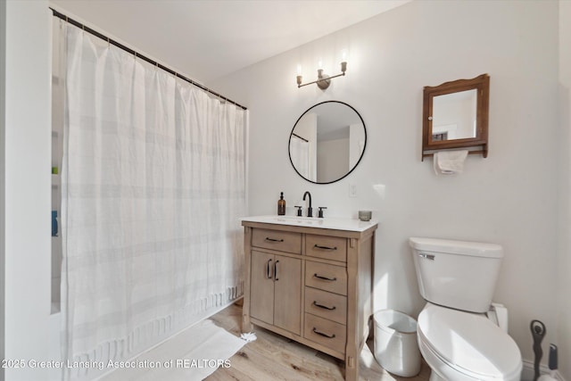 full bathroom featuring vanity, curtained shower, toilet, and wood finished floors