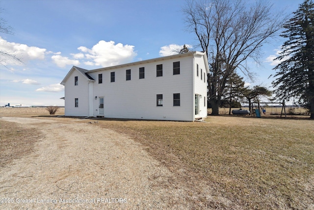 back of property with a lawn and driveway