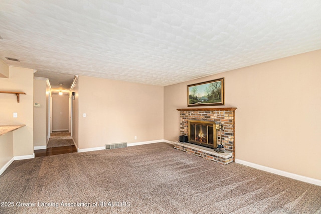 unfurnished living room featuring carpet, a fireplace, visible vents, and a textured ceiling